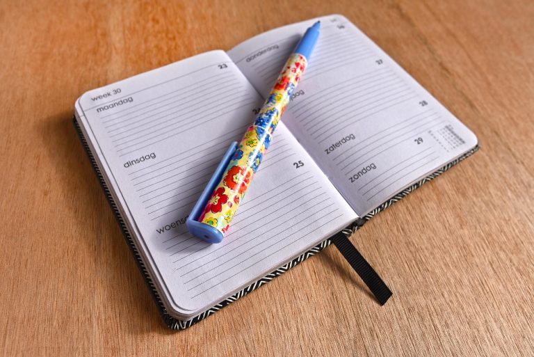 Planner mingguan dan pena di meja
