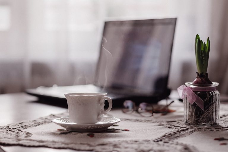 Meja kerja dengan laptop dan kopi di pagi hari